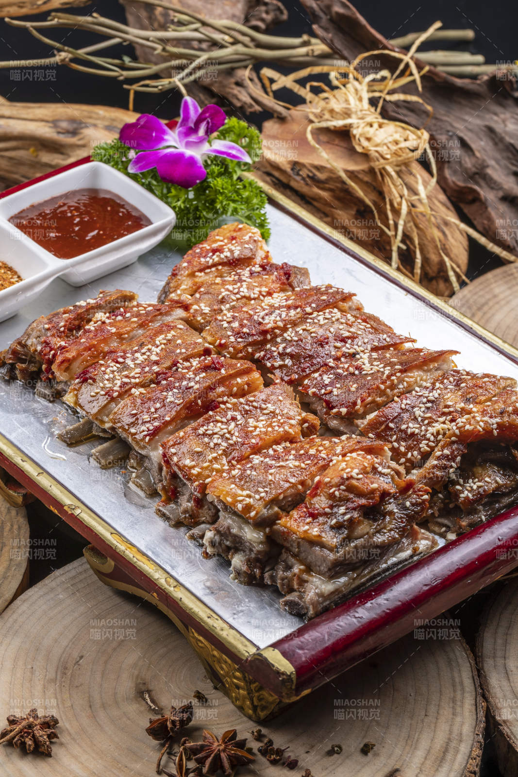 红色漆盘装的蒙古烤羊排摆放在樟木砧板上