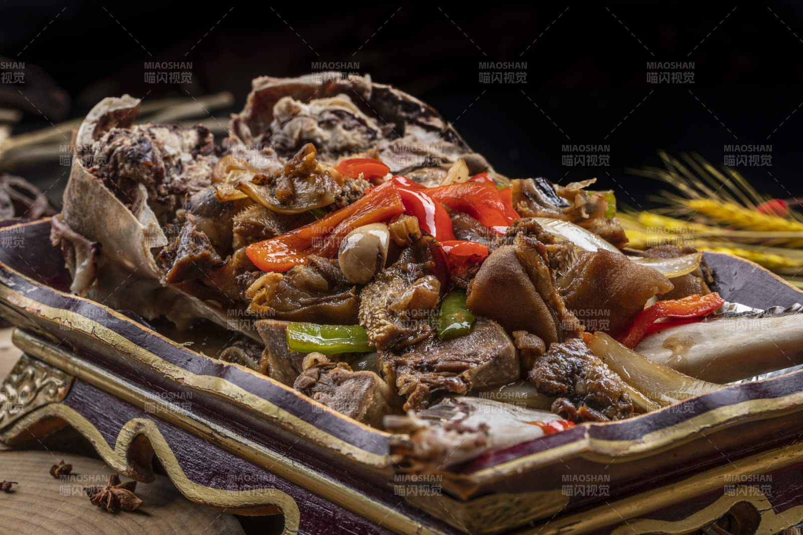 紅漆木盤裝的水煮蒜泥羊頭擺放在樟木砧板上