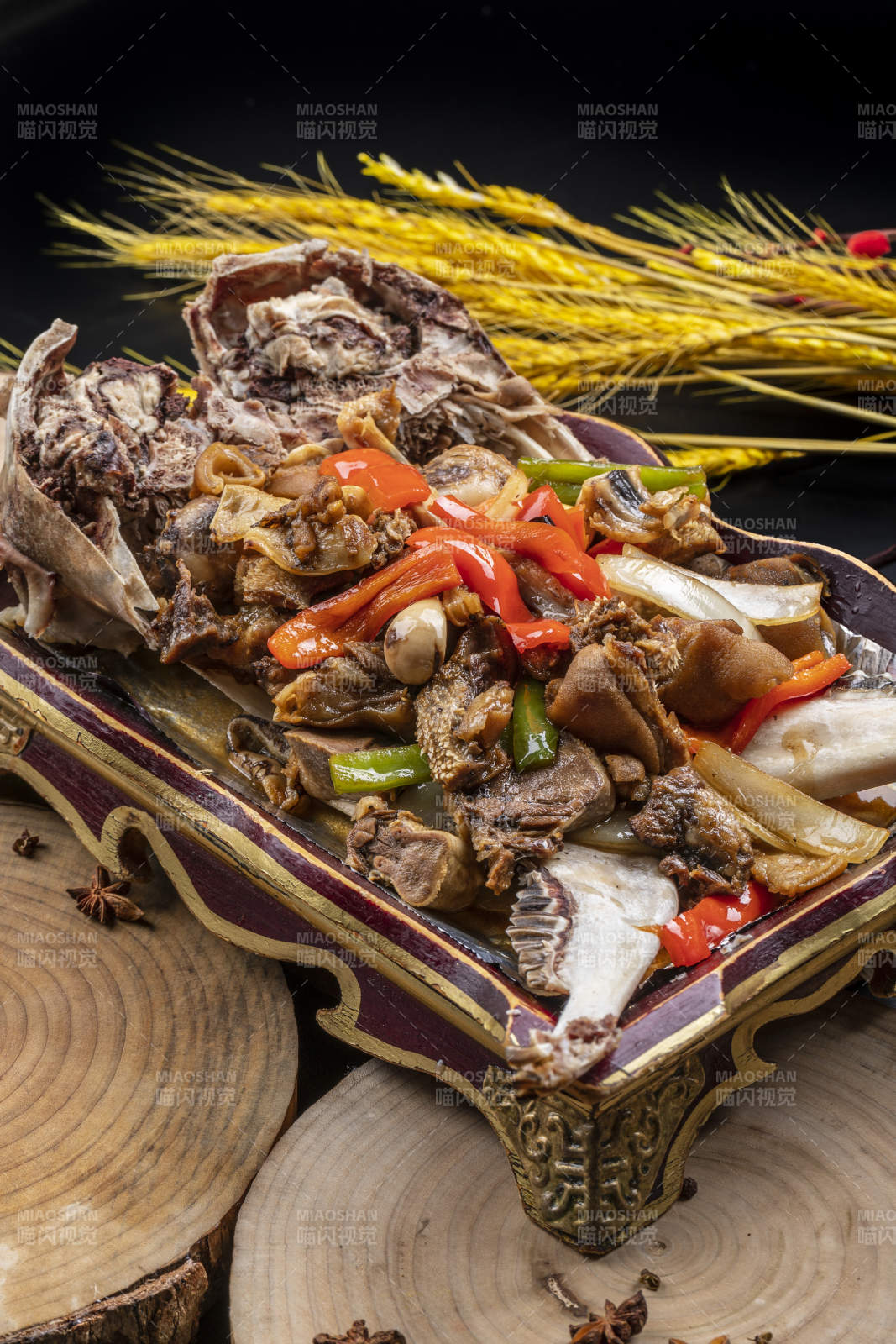 紅漆木盤裝的水煮蒜泥羊頭擺放在樟木砧板上