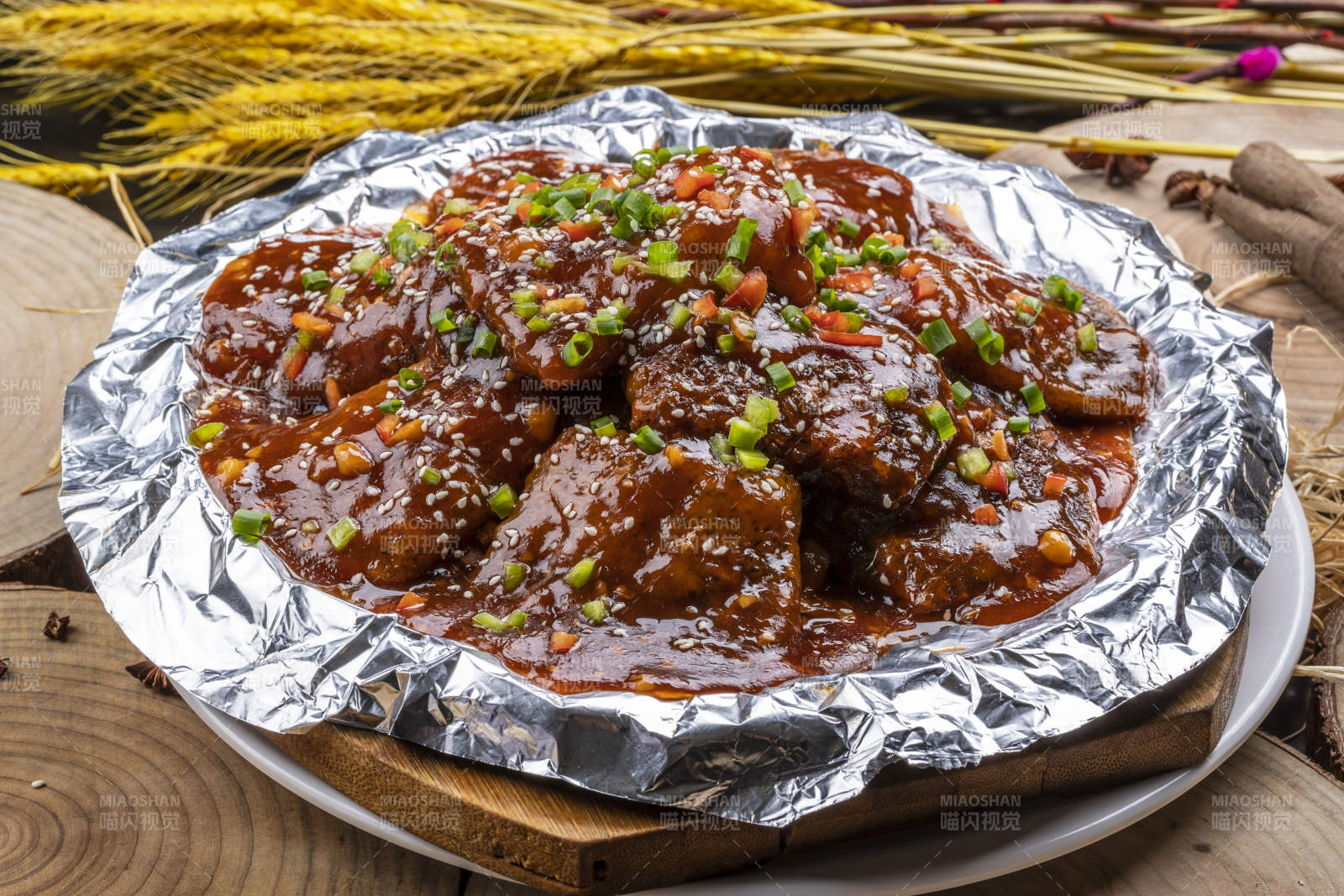 錫紙盤裝的紅燒脫骨帶魚擺放在樟木砧板上
