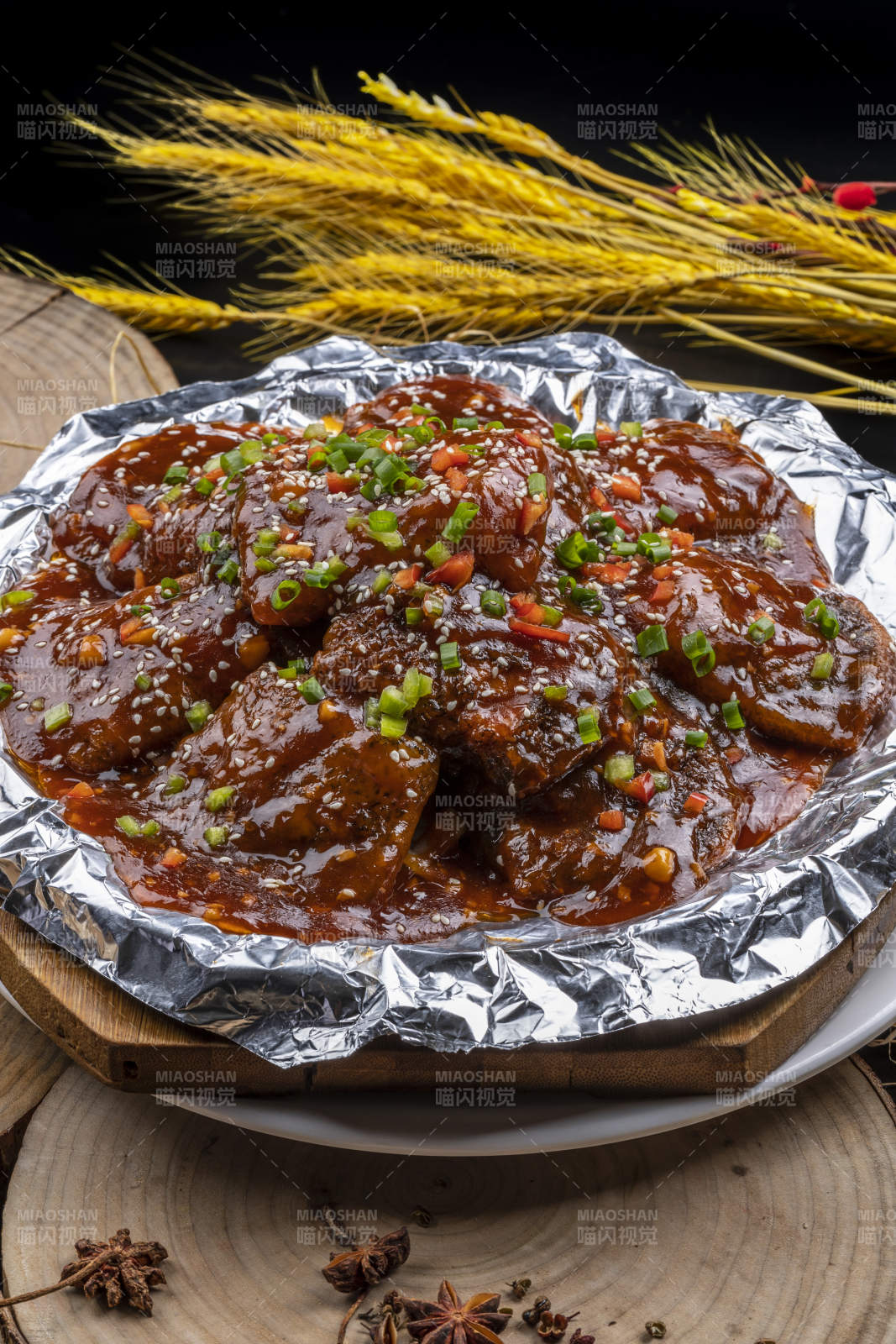 錫紙盤(pán)裝的紅燒脫骨帶魚(yú)擺放在樟木砧板上