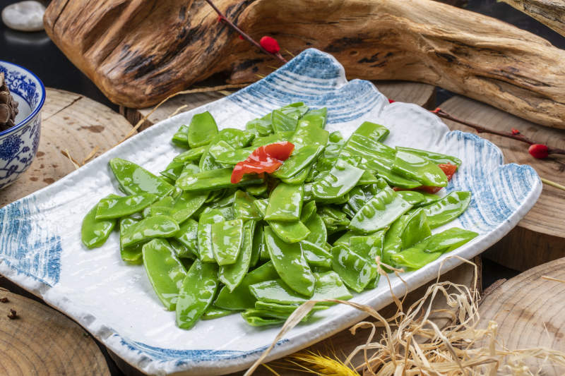 元瓷盘装的清炒时蔬蒜粒荷兰豆