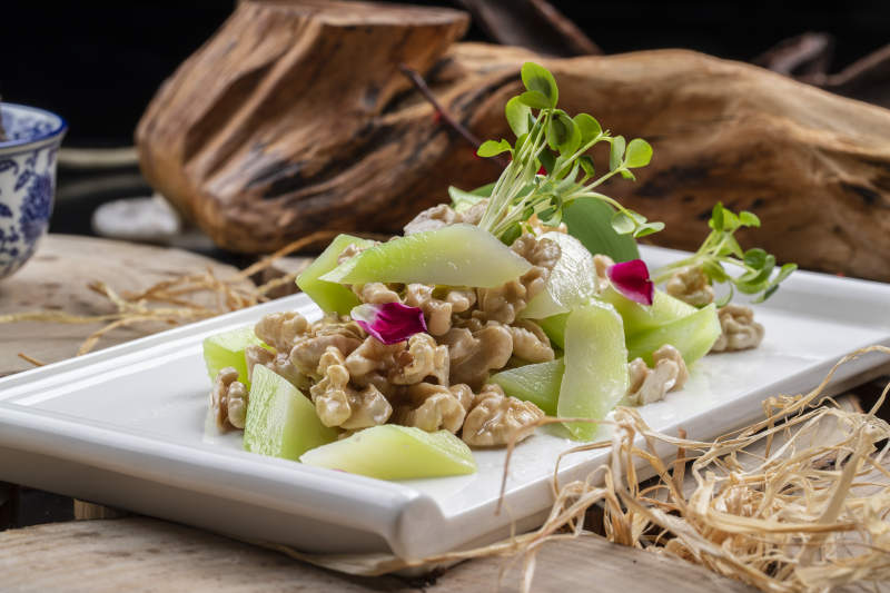 白瓷盘装的西芹鲜桃仁