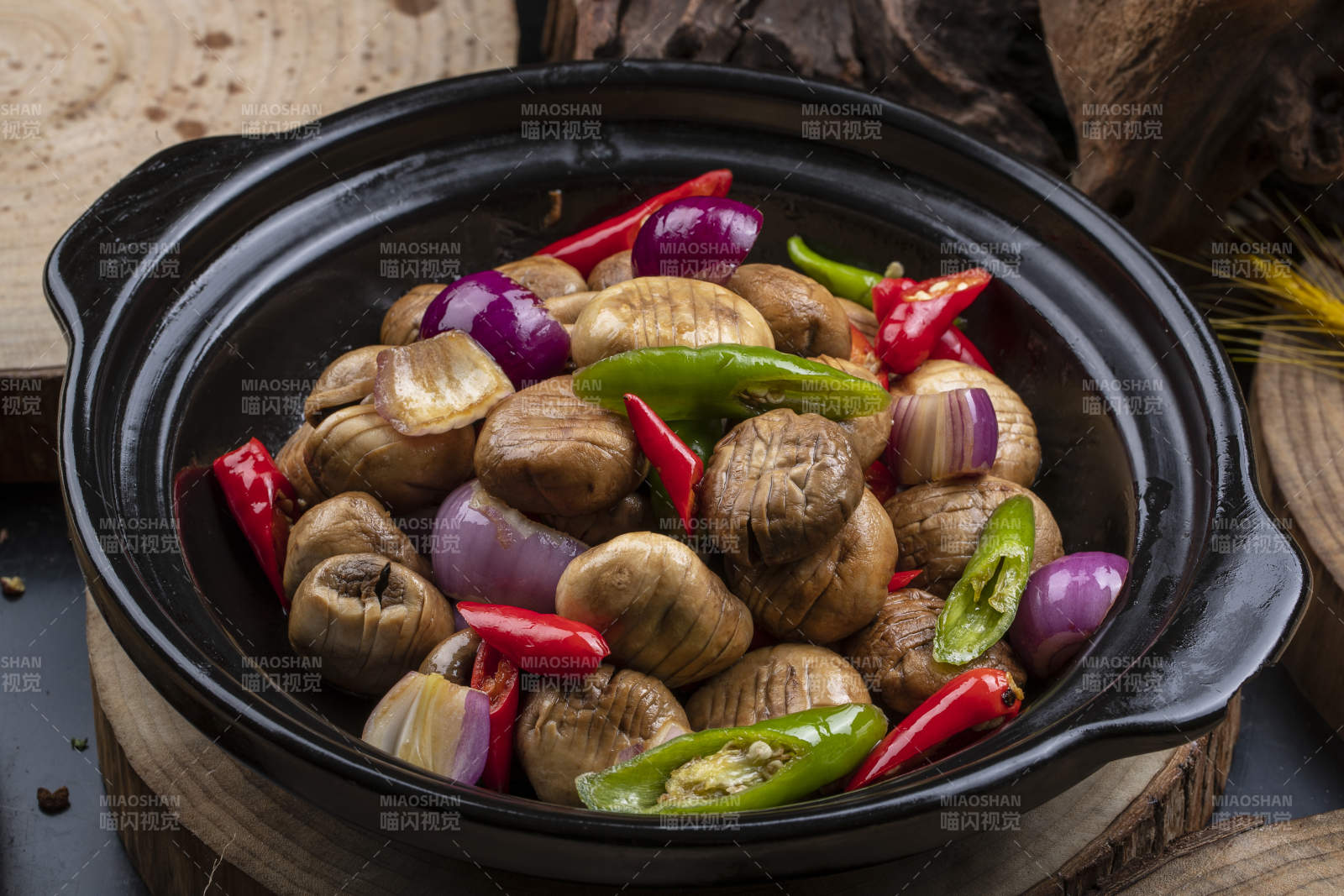 黑色砂锅装的小葱头鲜口蘑米椒煲