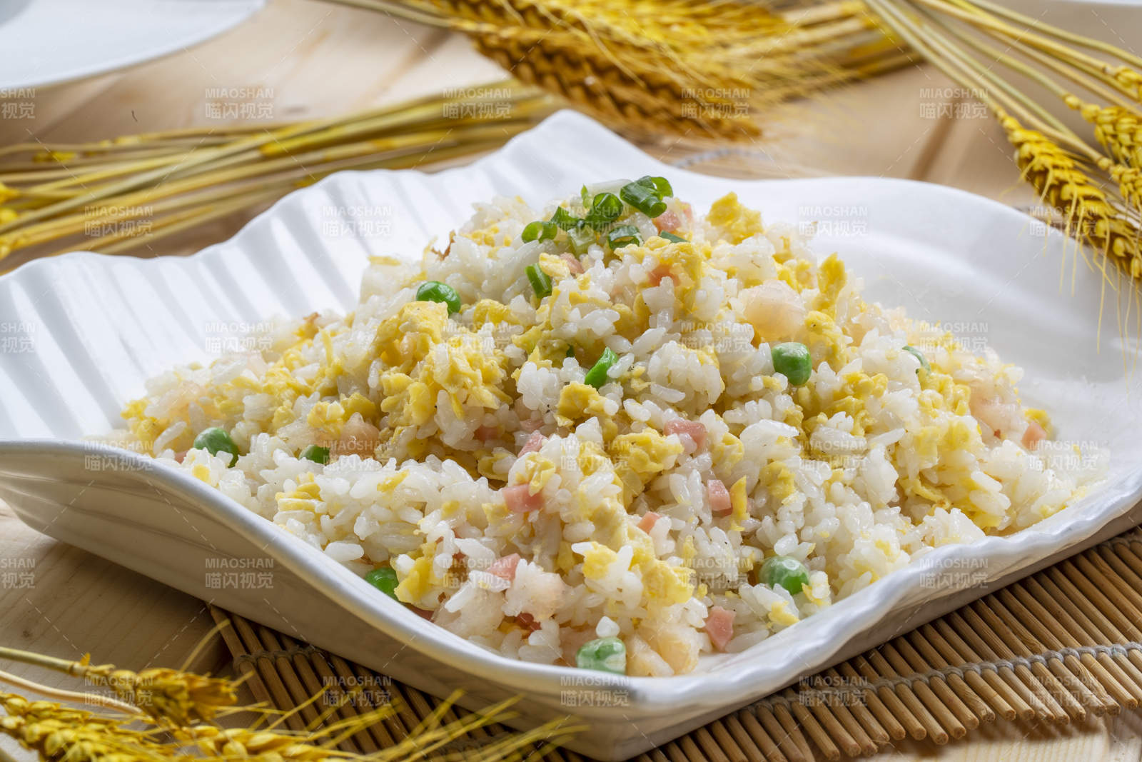 白瓷盤裝的火腿蝦仁青豆蛋炒飯