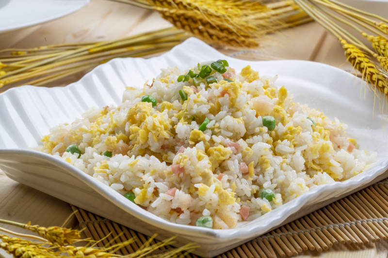 白瓷盘装的火腿虾仁青豆蛋炒饭