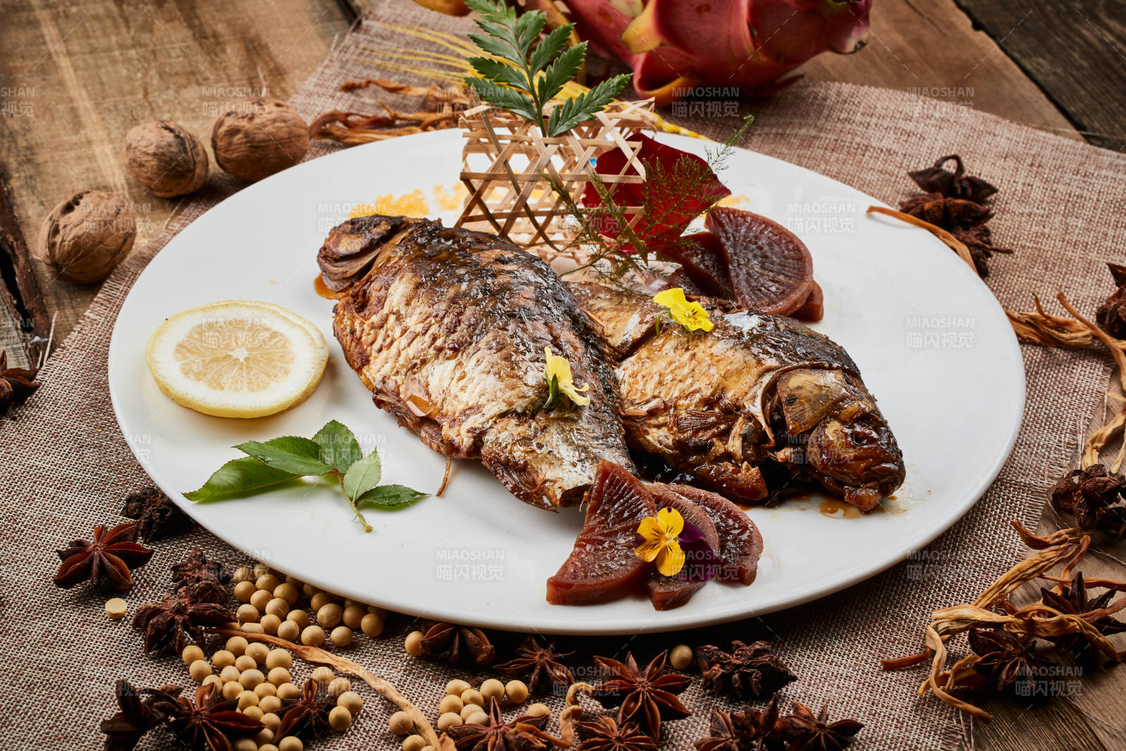 陈旧木板上的圆瓷盘装的家炖香酥鲫鱼