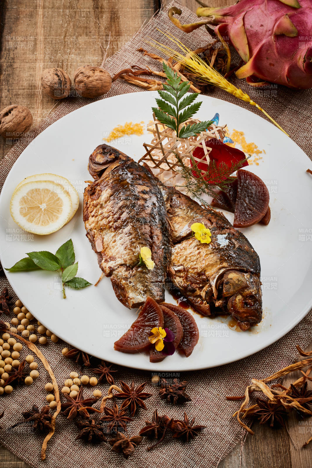 陈旧木板上的圆瓷盘装的家炖香酥鲫鱼