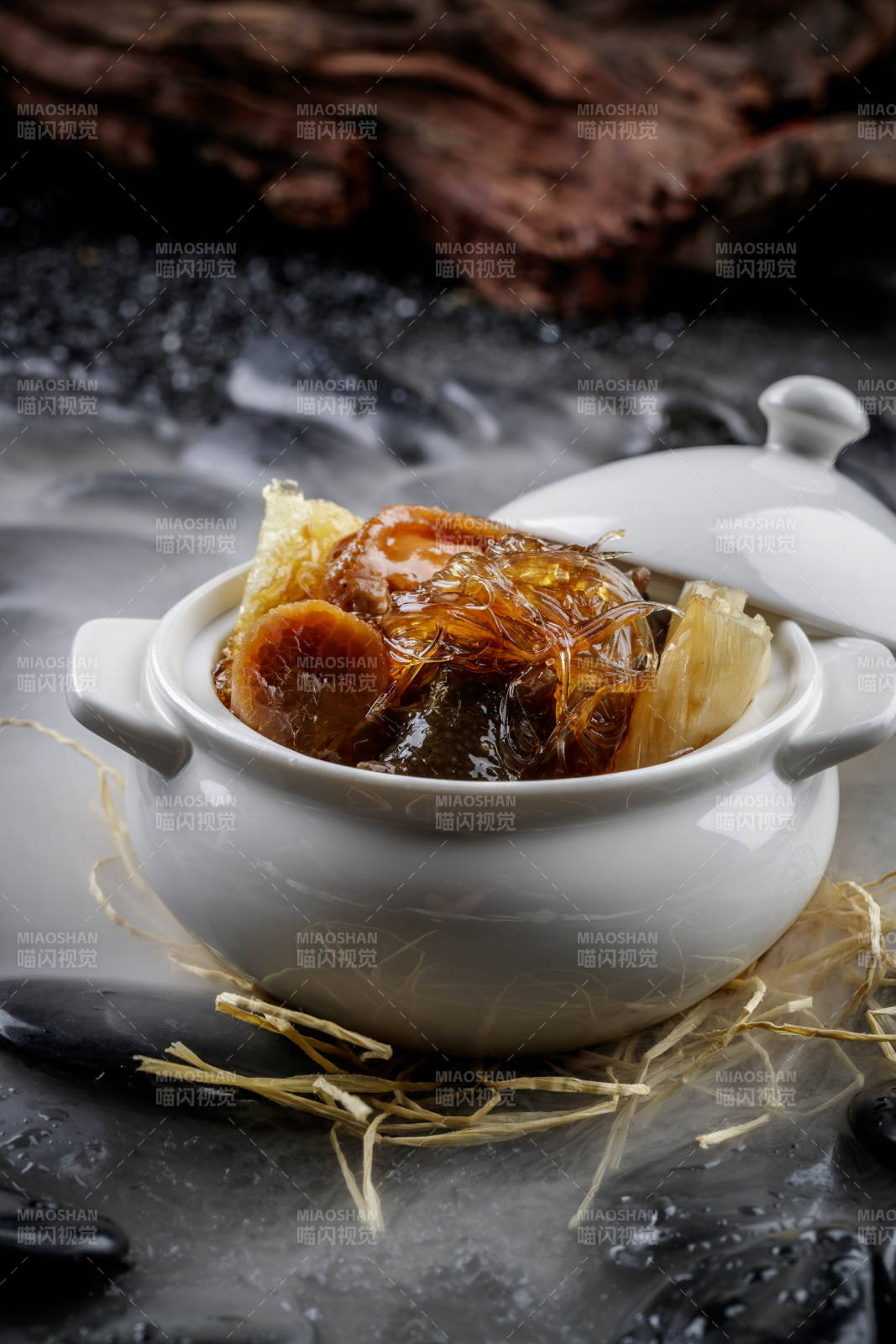 養生佛跳墻擺放在干冰繚繞的黑色鵝卵石山