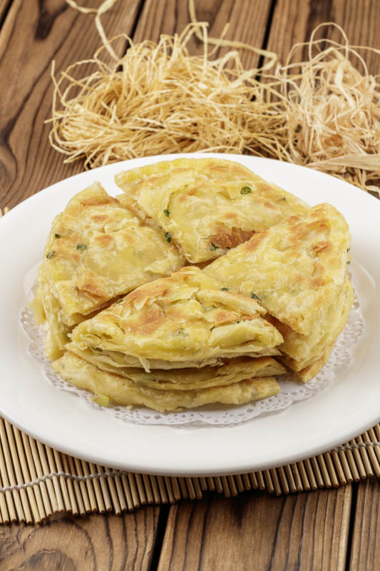 圆形白色瓷盘装的葱花饼