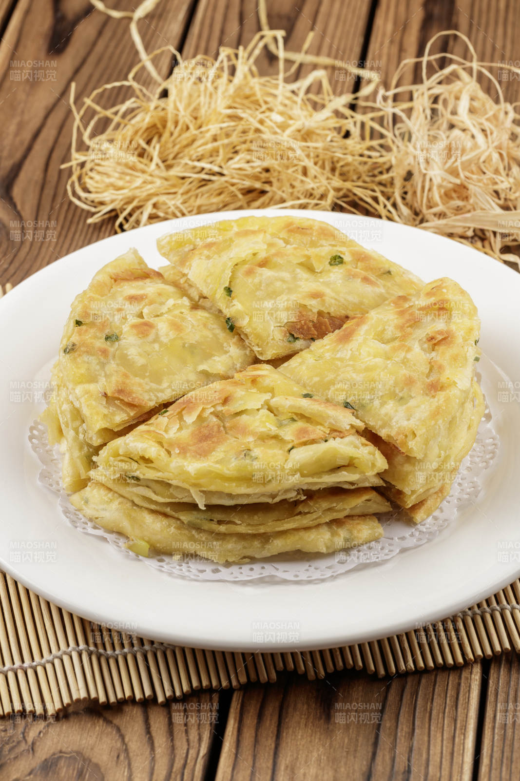 圆形白色瓷盘装的葱花饼