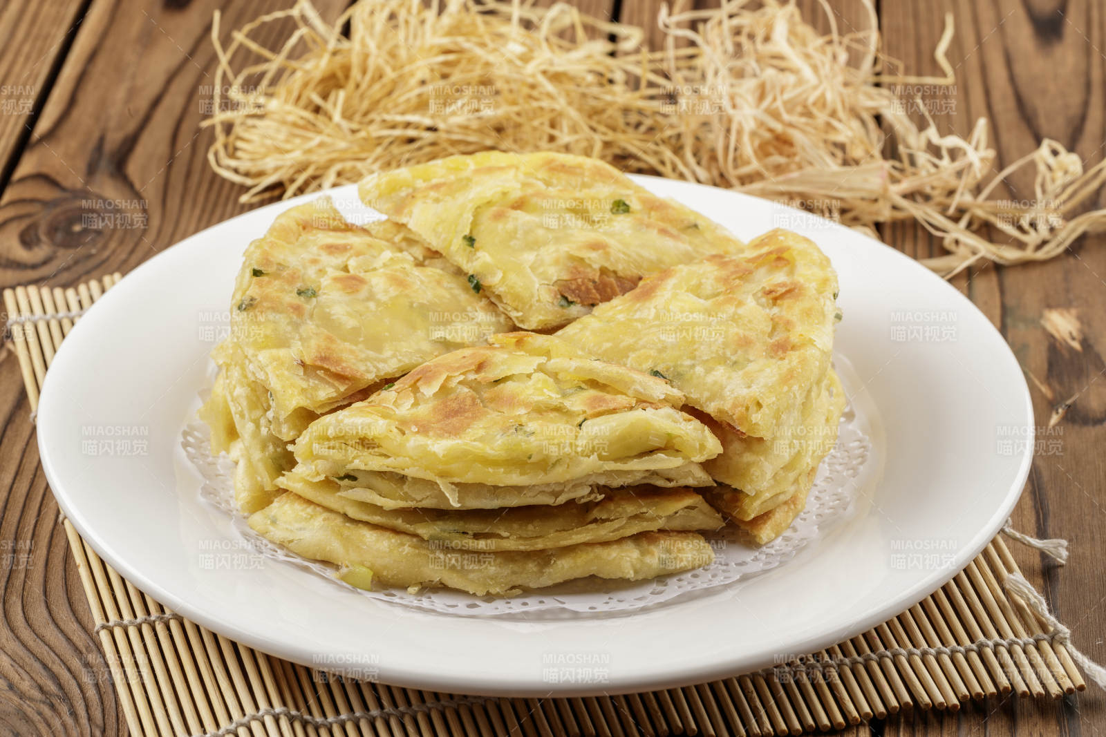 圆形白色瓷盘装的葱花饼