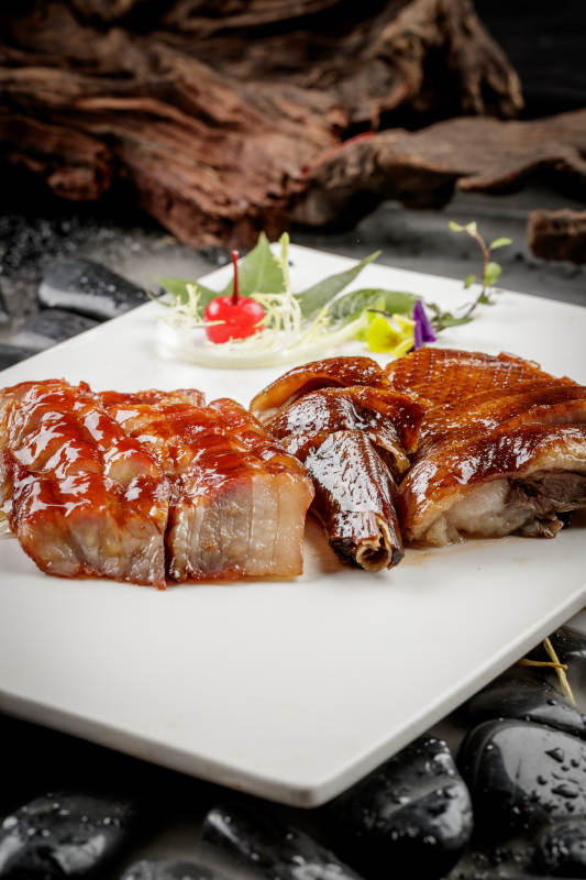 烧腊双拼摆放在干冰缭绕的鹅卵石上