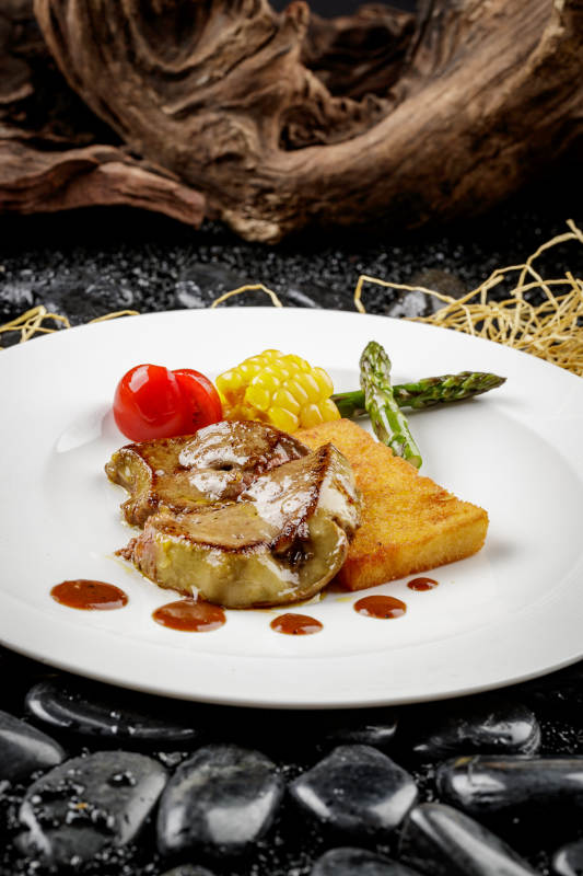 煎法式鹅肝摆放在黑色鹅卵石上