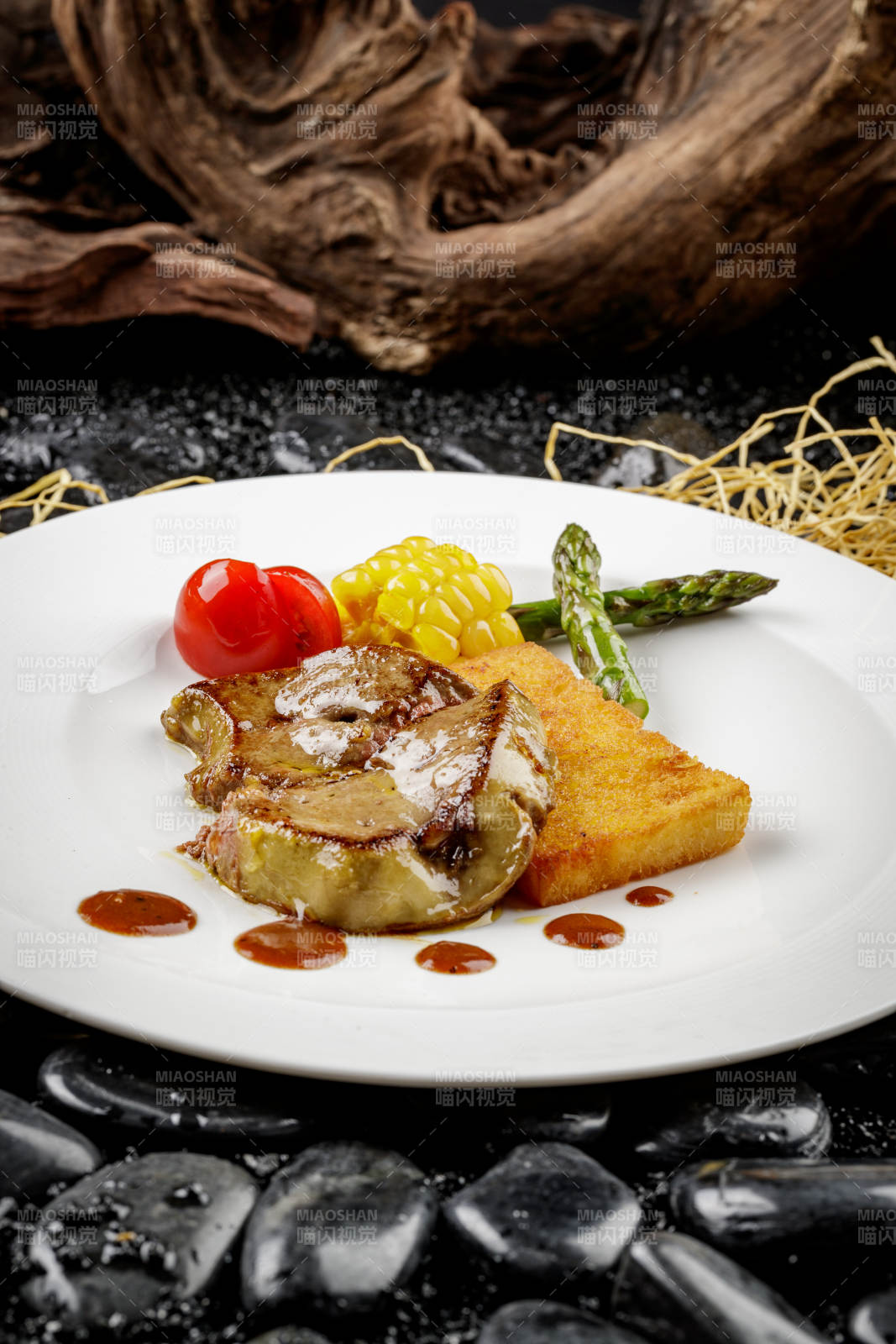 煎法式鹅肝摆放在黑色鹅卵石上