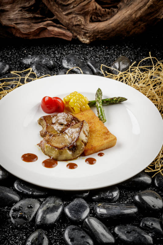 煎法式鹅肝摆放在黑色鹅卵石上