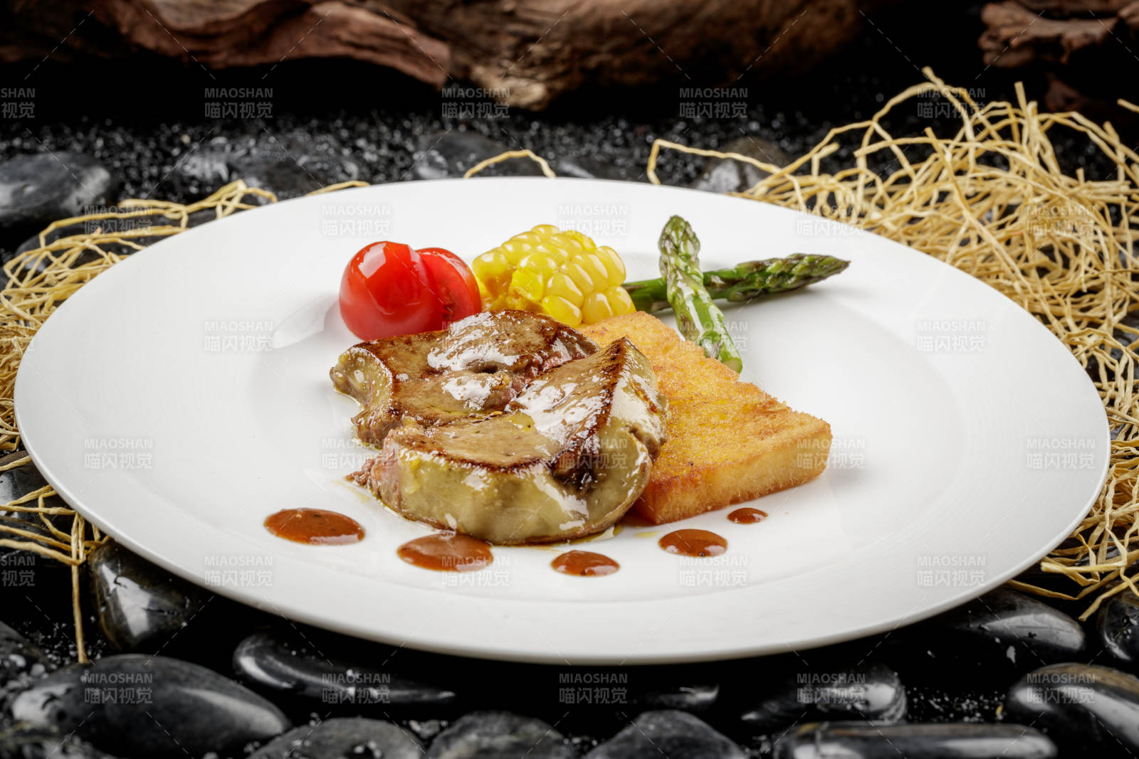 煎法式鹅肝摆放在黑色鹅卵石上