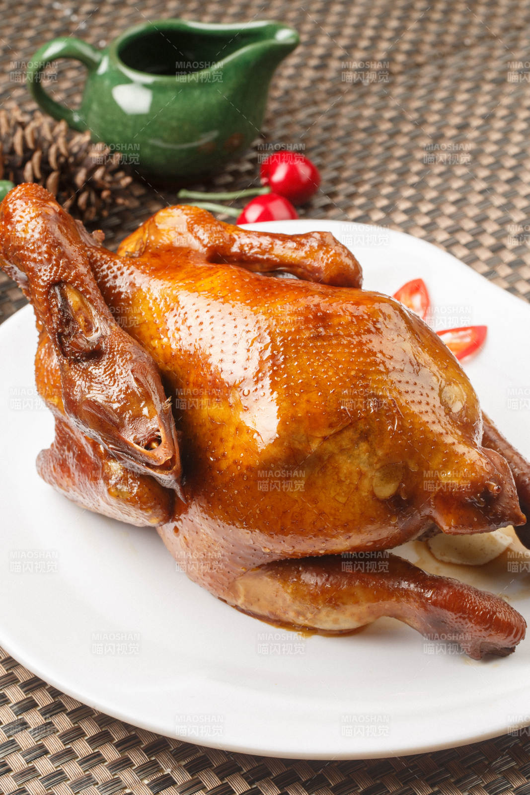 白色圆瓷盘装的港式脆皮鸡摆放在餐垫上