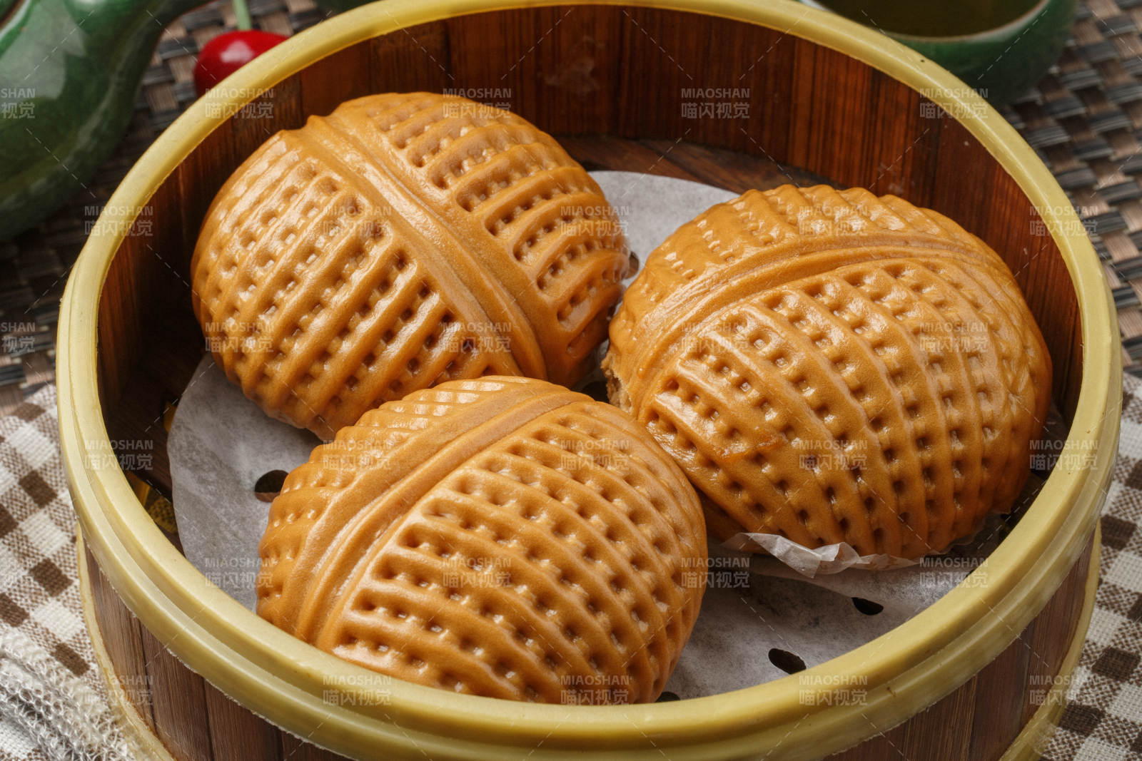 笼屉装的港式奶油菠萝包摆放在餐布上