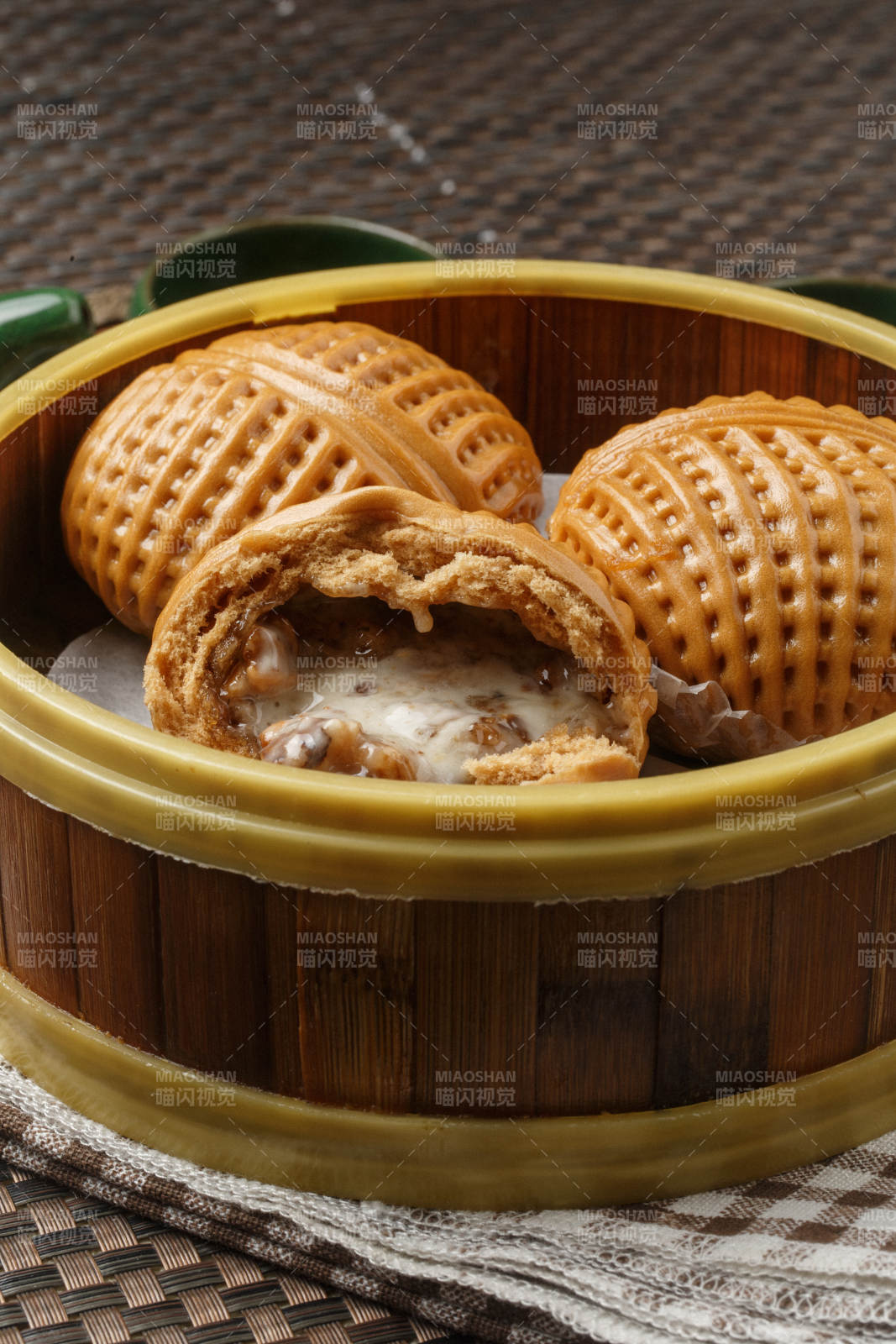 笼屉装的港式奶油菠萝包摆放在餐布上