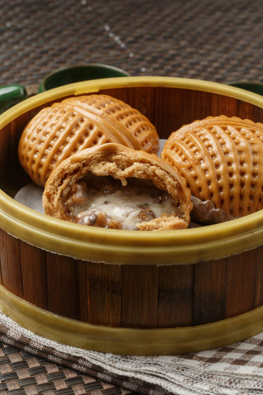 笼屉装的港式奶油菠萝包摆放在餐布上