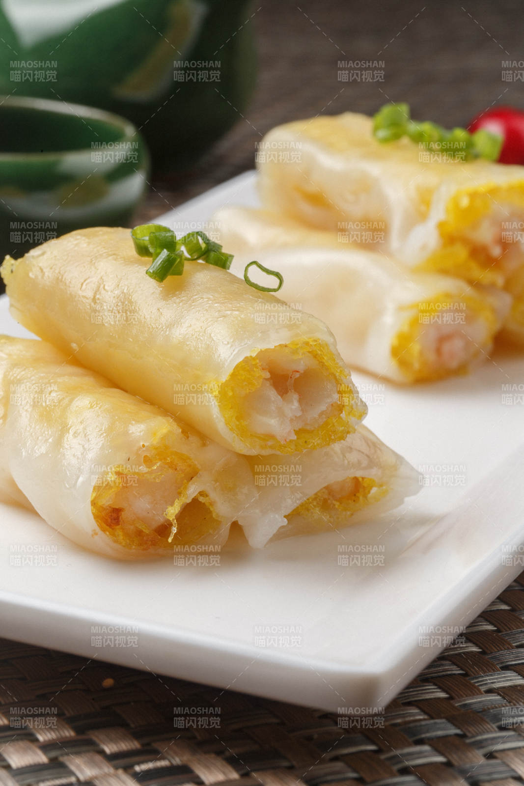 长方形白瓷盘装的虾仁肠粉摆放在餐垫上