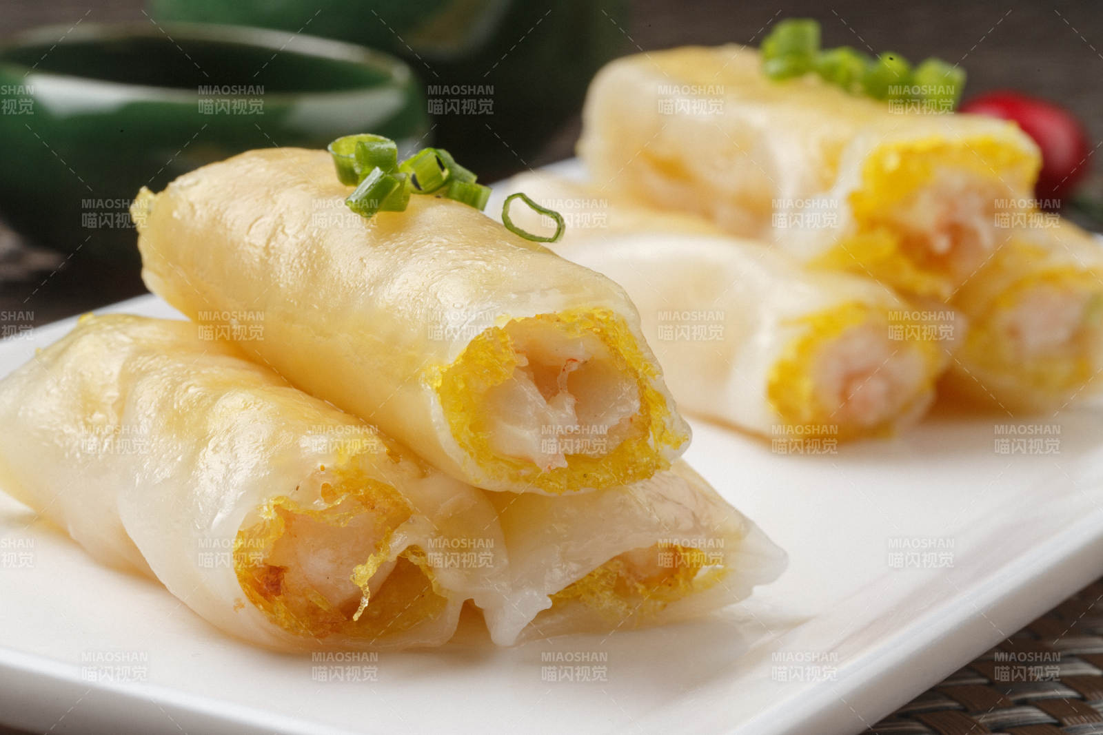 长方形白瓷盘装的虾仁肠粉摆放在餐垫上