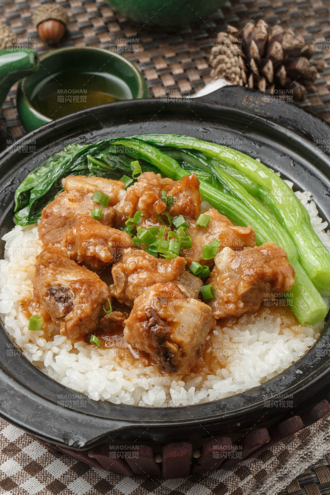 黑色砂锅装的虫草花排骨煲白粥摆放在餐布上