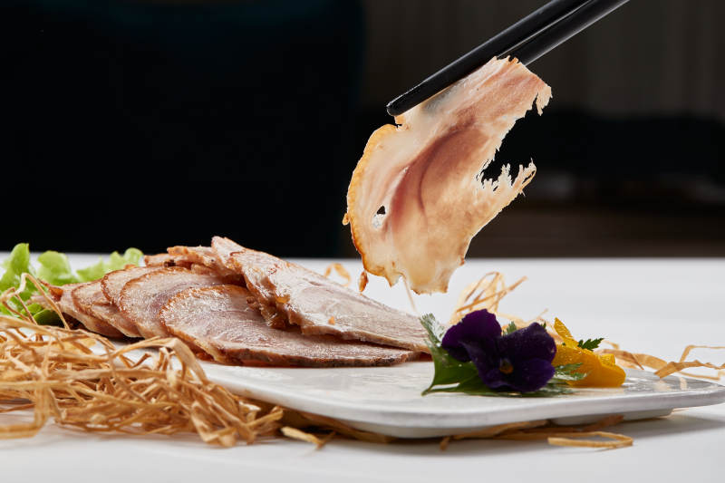 白色瓷盤裝的煙熏豬肘五花肉