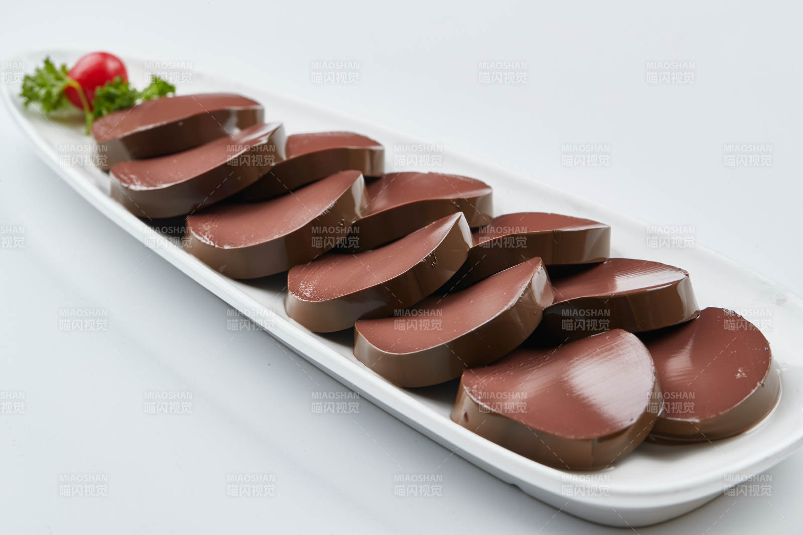 白色瓷盘装的的火锅食材鸭血切片