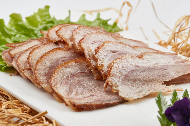 白色瓷盤裝的煙熏豬肘五花肉