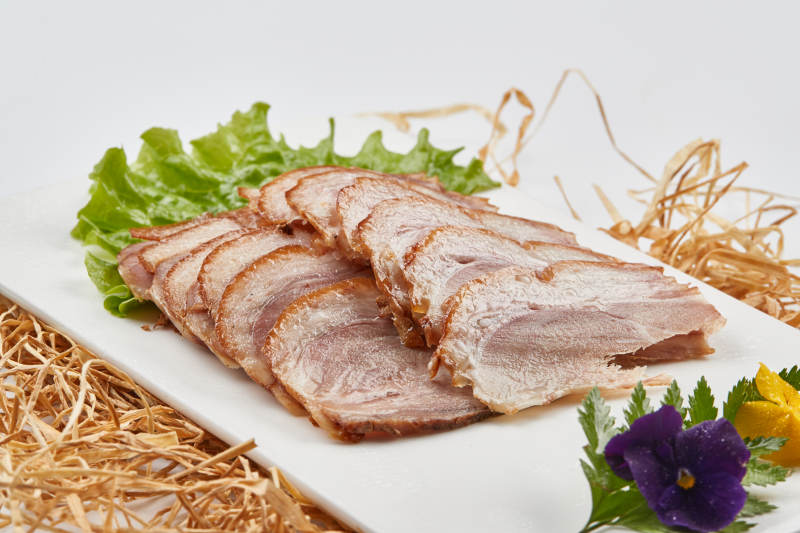 白色瓷盤裝的煙熏豬肘五花肉