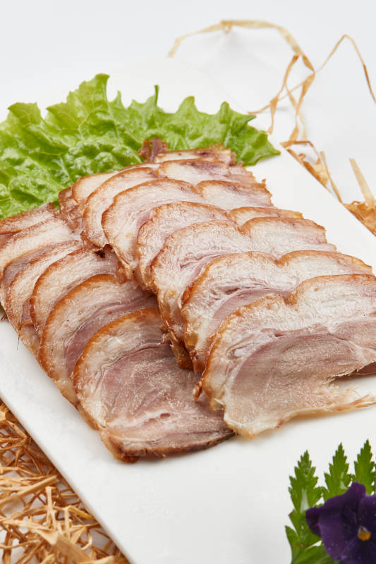 白色瓷盤裝的煙熏豬肘五花肉