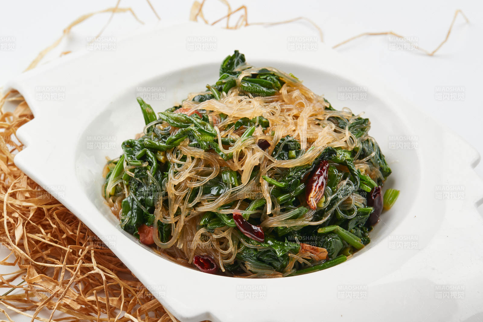 白色瓷盘装的凉拌粉丝菠菜