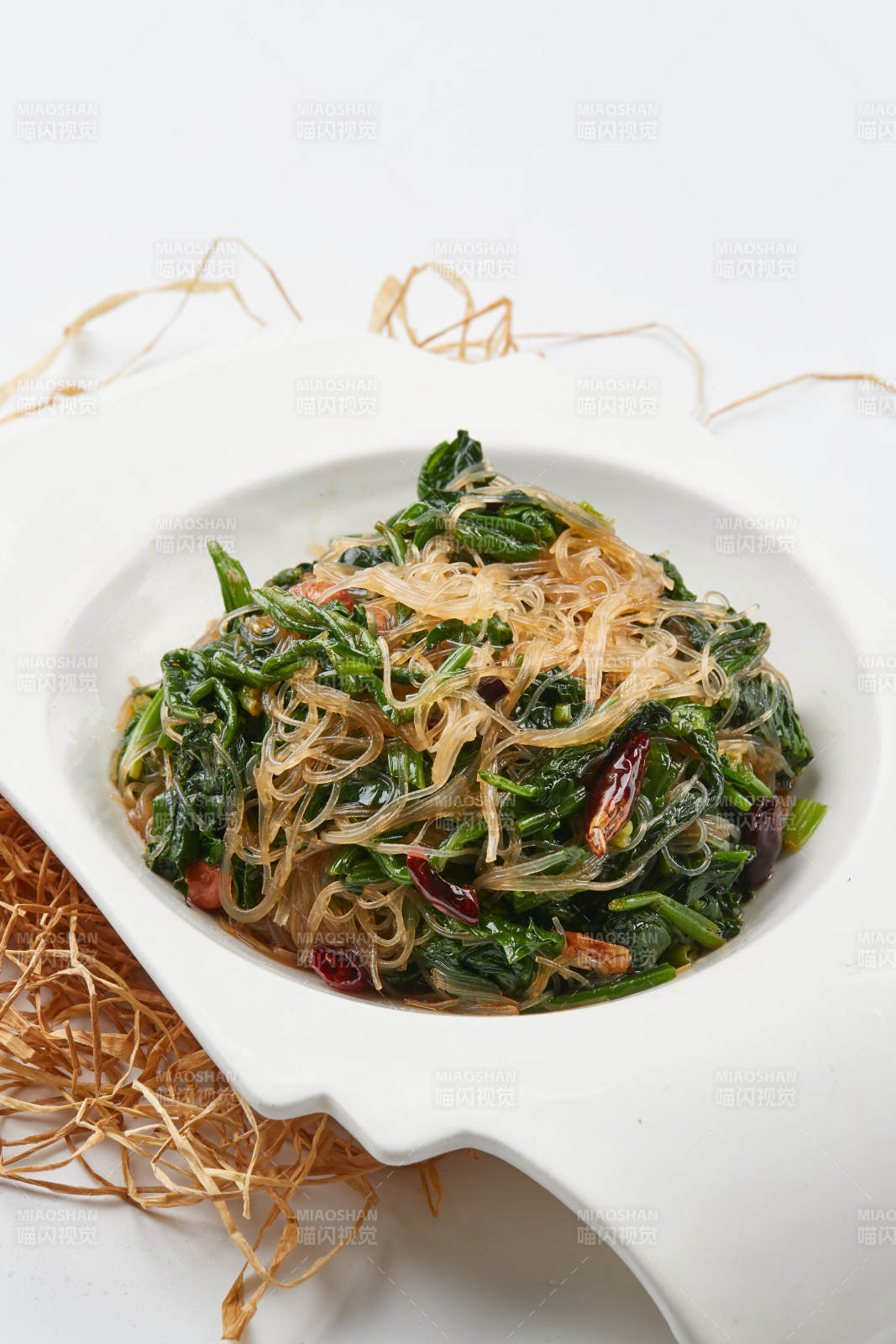 白色瓷盘装的凉拌粉丝菠菜