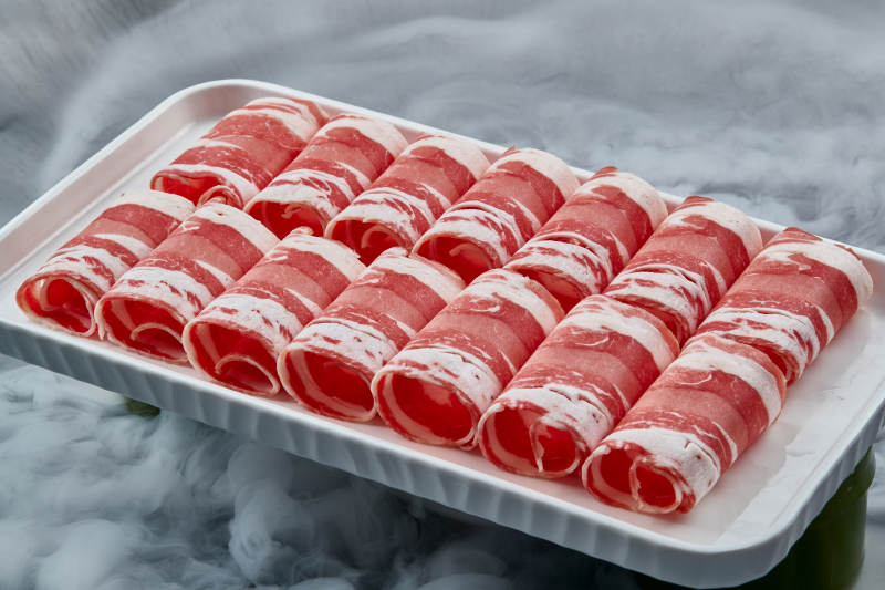 干冰繚繞的背景上擺放的草原肥羊肉卷