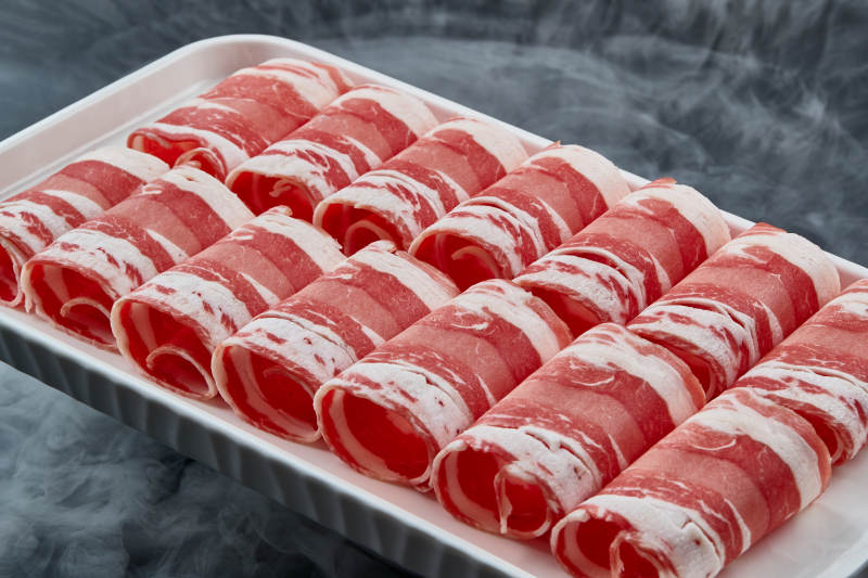 干冰缭绕的背景上摆放的草原肥羊肉卷