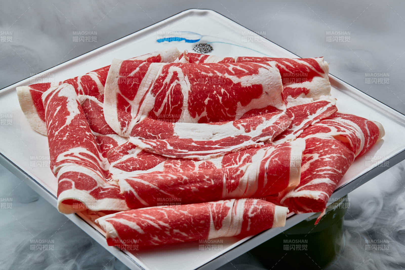 干冰缭绕的背景上摆放的上脑和牛切片