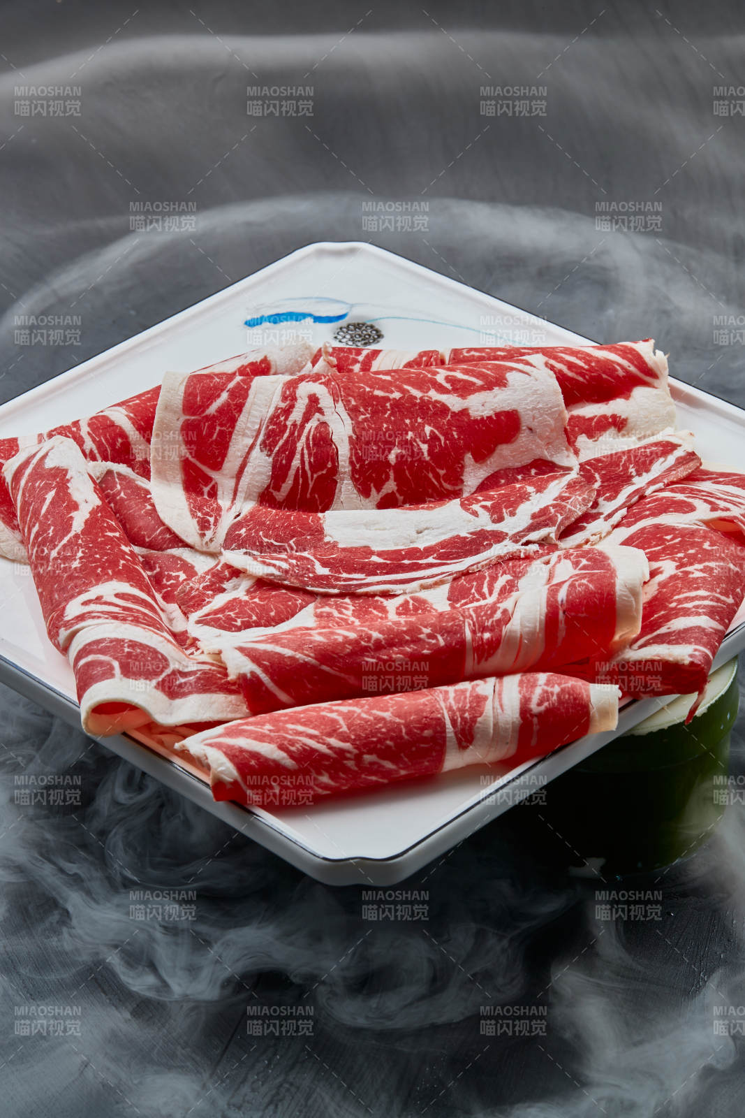 干冰缭绕的背景上摆放的上脑和牛切片