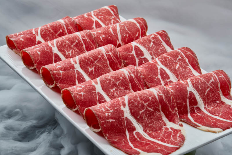 干冰缭绕的背景上摆放的高级雪花肥牛切片