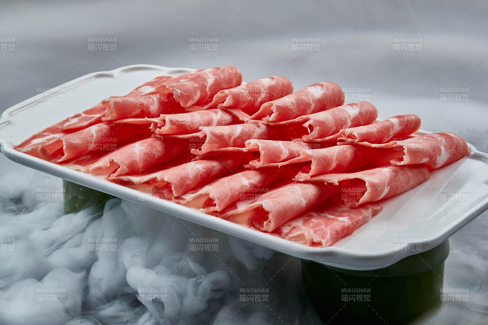 干冰繚繞的背景上擺放的牛肉切片