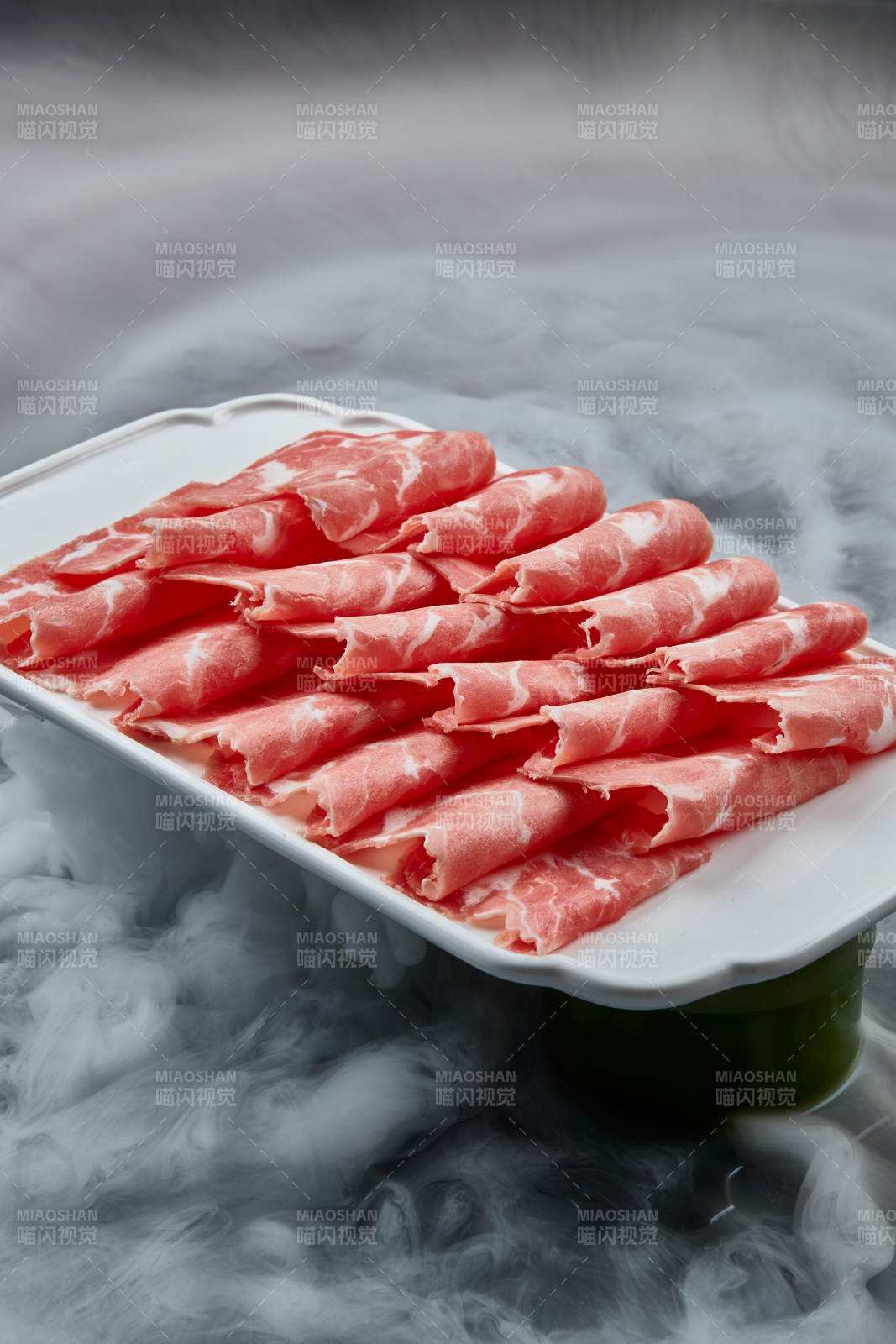 干冰繚繞的背景上擺放的牛肉切片