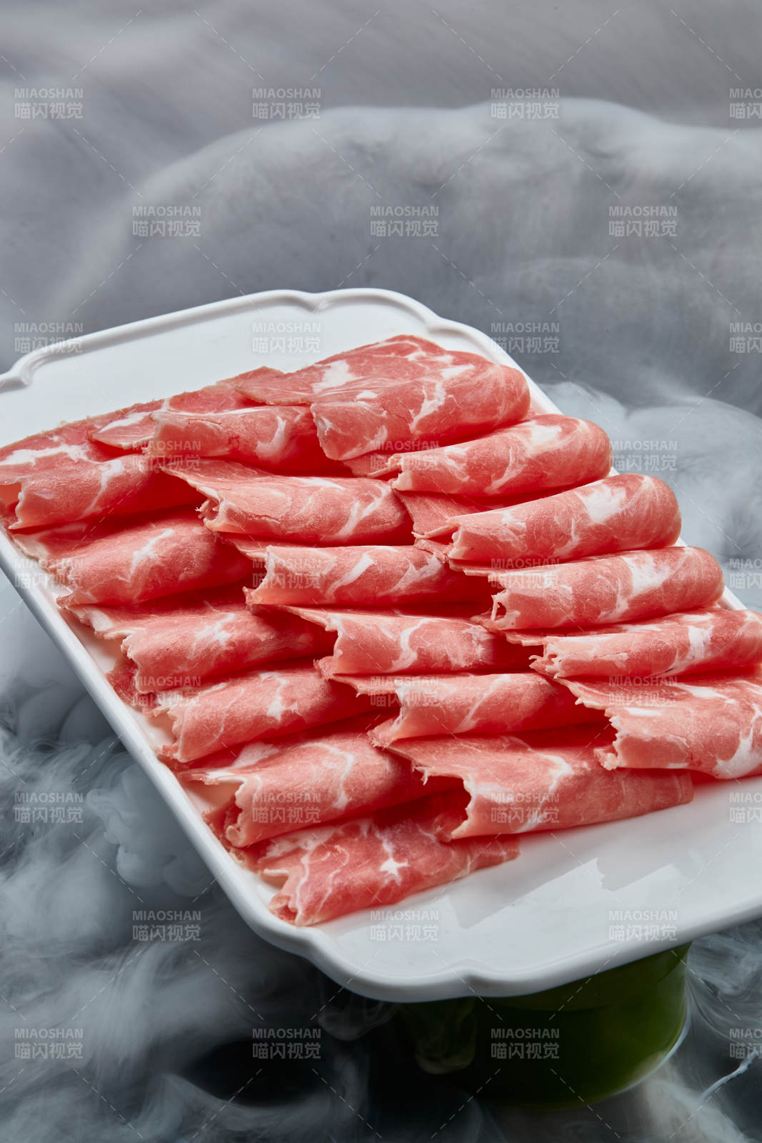 干冰繚繞的背景上擺放的牛肉切片