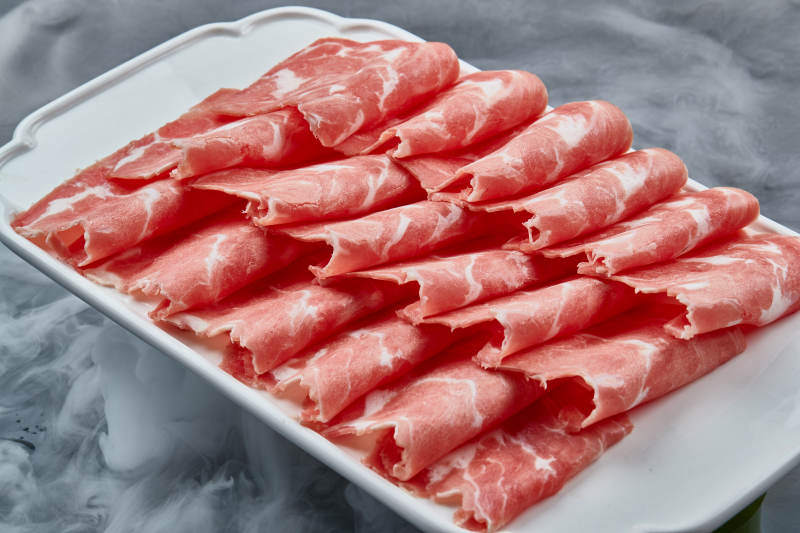 干冰繚繞的背景上擺放的牛肉切片