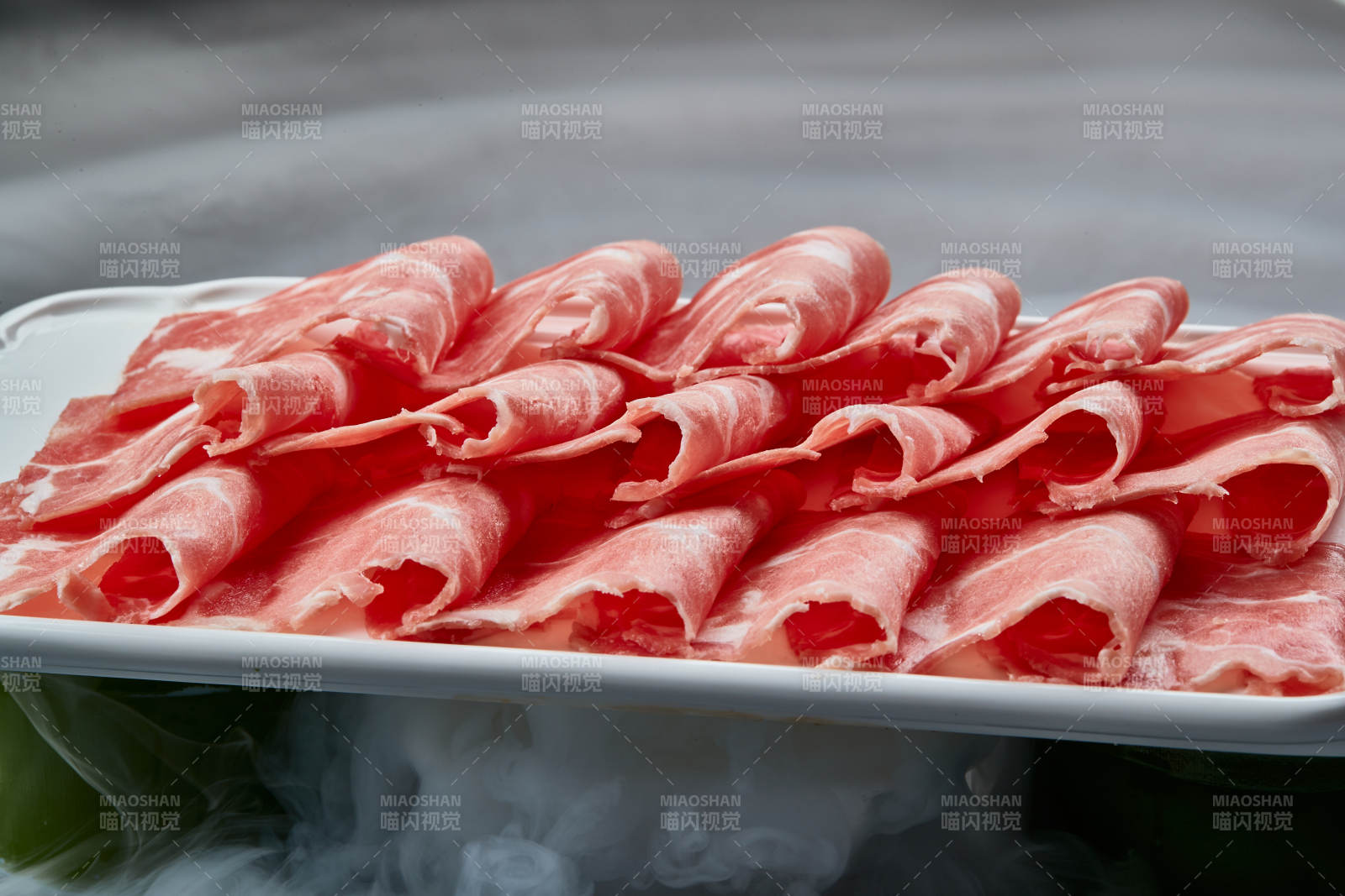 干冰繚繞的背景上擺放的牛肉切片