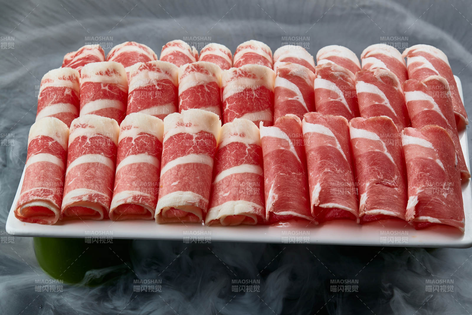 干冰繚繞的背景上擺放的牛羊肉卷雙拼