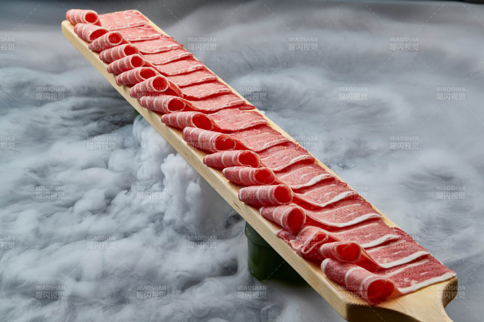 干冰缭绕的背景上摆放的和牛一米肉片