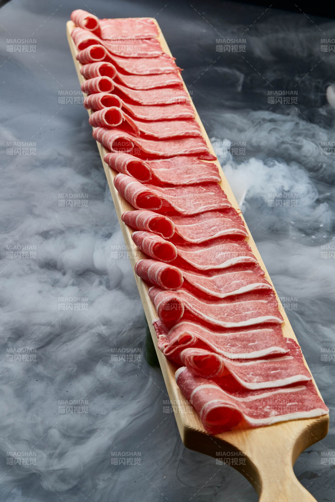 干冰缭绕的背景上摆放的和牛一米肉片