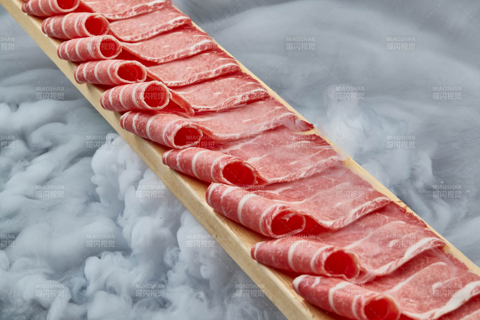 干冰缭绕的背景上摆放的和牛一米肉片