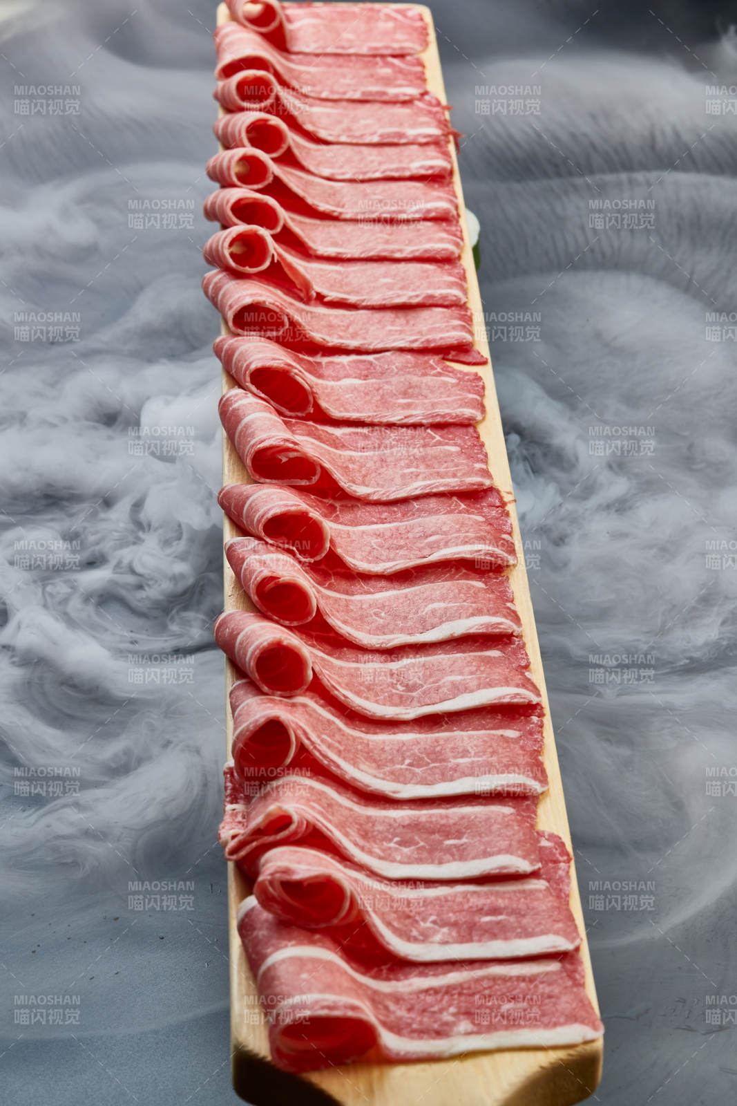 干冰缭绕的背景上摆放的和牛一米肉片